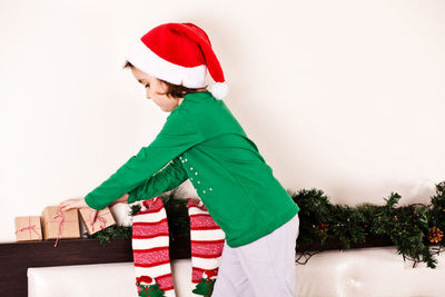 Side view of girl arranging christmas gift at home