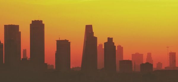 Silhouette buildings against sky during sunset