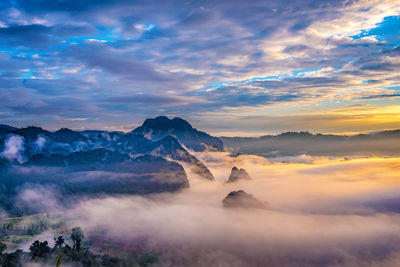 Scenic view of mountains against dramatic sky during sunset