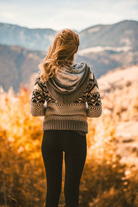 Rear view of woman standing on field