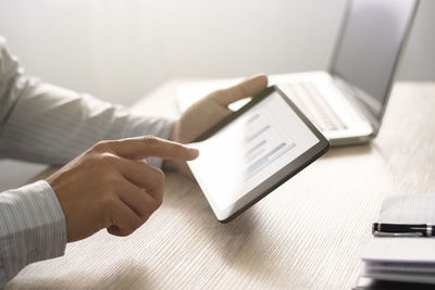 Midsection of man using laptop on table