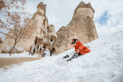 People skiing on snow covered landscape