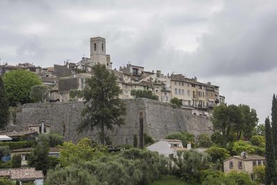 Buildings in city against cloudy sky