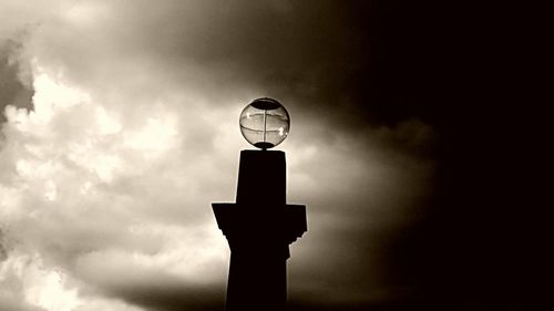 Low angle view of street light against cloudy sky