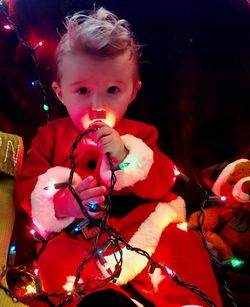 Portrait of cute girl with illuminated christmas lights