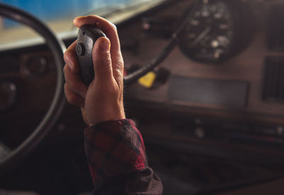 Cropped hand of man sitting in truck