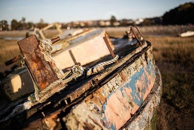 Close-up of old abandoned boat against sky