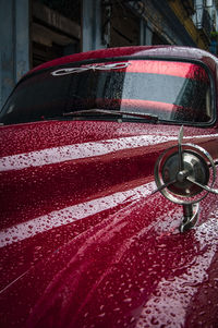 Close-up of wet red car in city