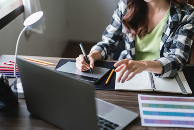 Midsection of woman working at office