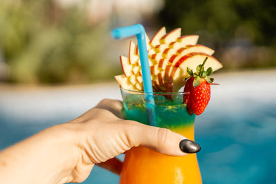 Midsection of woman holding strawberry