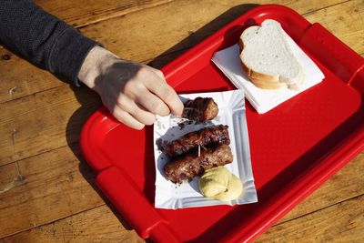 Cropped hand having meat at restaurant