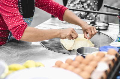 Midsection of woman preparing food in kitchen at home