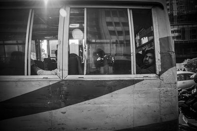 Reflection of people on glass window of train