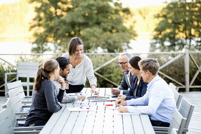 Group of business people working at table on patio