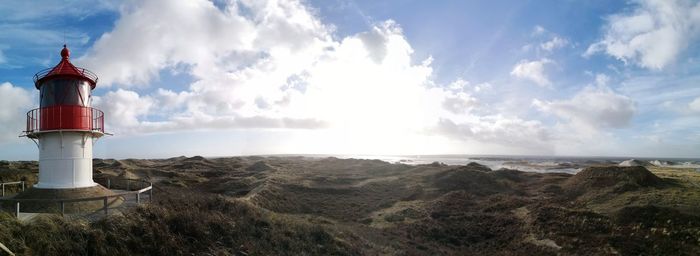 Panoramic view of lighthouse by sea against sky