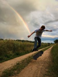 Man running on beach against cloudy sky