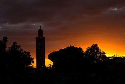 Silhouette trees and buildings against sky during sunset