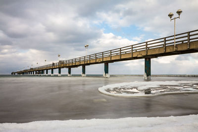 Bridge over sea against sky during winter