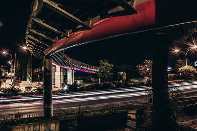 Light trails below bridge in city at night