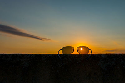 Silhouette sunglasses against sky during sunset