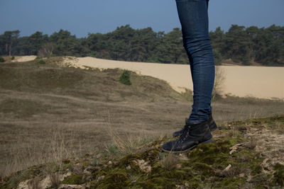 Low section of woman standing on landscape