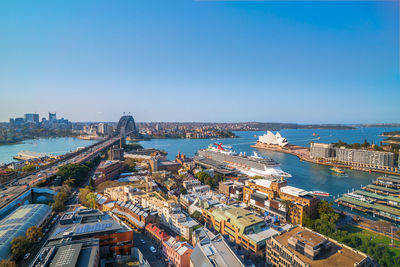 High angle view of buildings by sea against clear sky