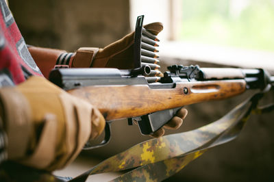 Midsection of man holding rifle