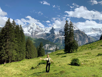 Man standing on field against mountain range