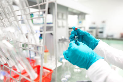 Cropped hand of scientist holding vial in laboratory