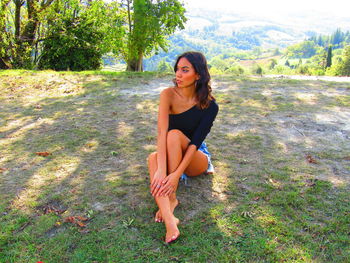Portrait of young woman sitting on grass