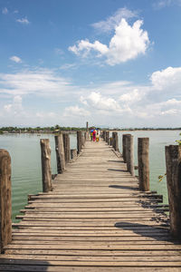 Wooden pier on sea against sky