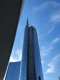 Low angle view of modern building against cloudy sky