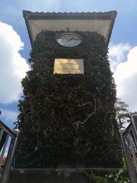 Low angle view of cross by building against sky