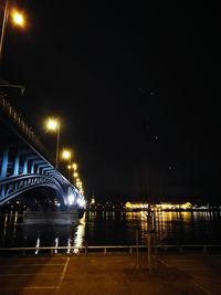 Illuminated bridge against sky at night