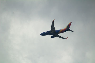 Low angle view of airplane flying against sky