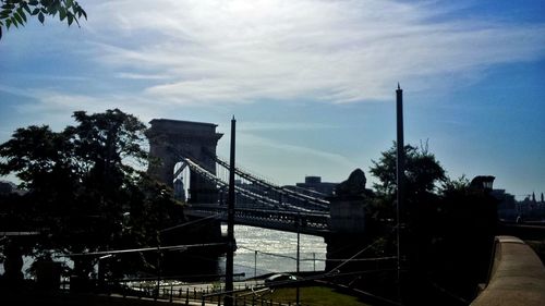 View of bridge in city against cloudy sky