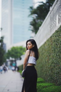 Side view of a young woman standing in city