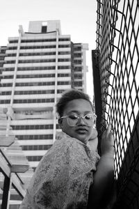 Portrait of woman standing against brick wall