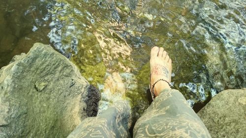 Low section of woman standing in water