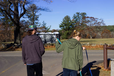 Rear view of friends standing on roadside