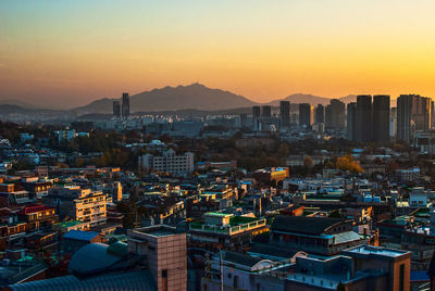 High angle view of illuminated cityscape against sky during sunset