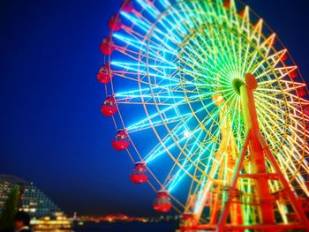 Low angle view of illuminated ferris wheel against sky at night