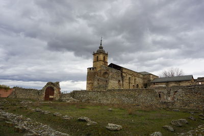 Old tower amidst buildings against sky