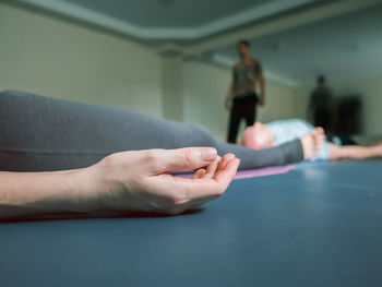 Low section of woman doing yoga in studio