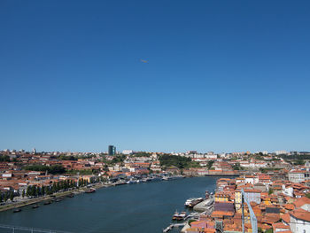 Aerial view of buildings in city against clear blue sky