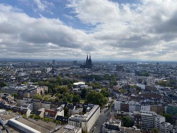 High angle view of city buildings against cloudy sky