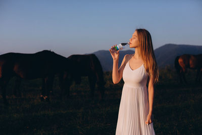 Woman standing on field against sky