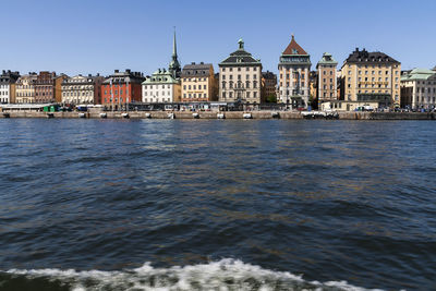 Lake against buildings in town against sky