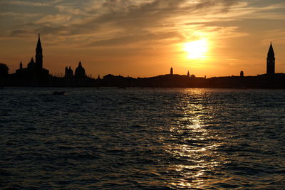 Silhouette of buildings against sky during sunset