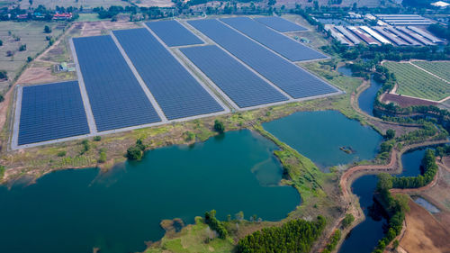 Solar panels farm between agriculture fields in aerial view. in thailand